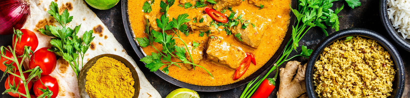 Asiatisches Hähnchen Curry mit verschiedenen frischen Zutaten auf dem Tisch